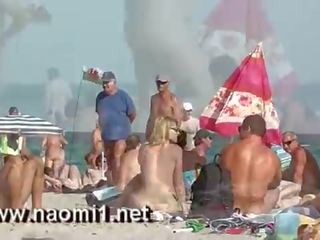 Naomi1 branlette une jeune youngster sur une publique plage